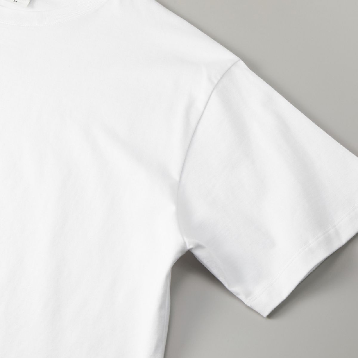 The armholes are finished with overlock stitching, and the cuffs are finished with a narrow double-needle stitch.