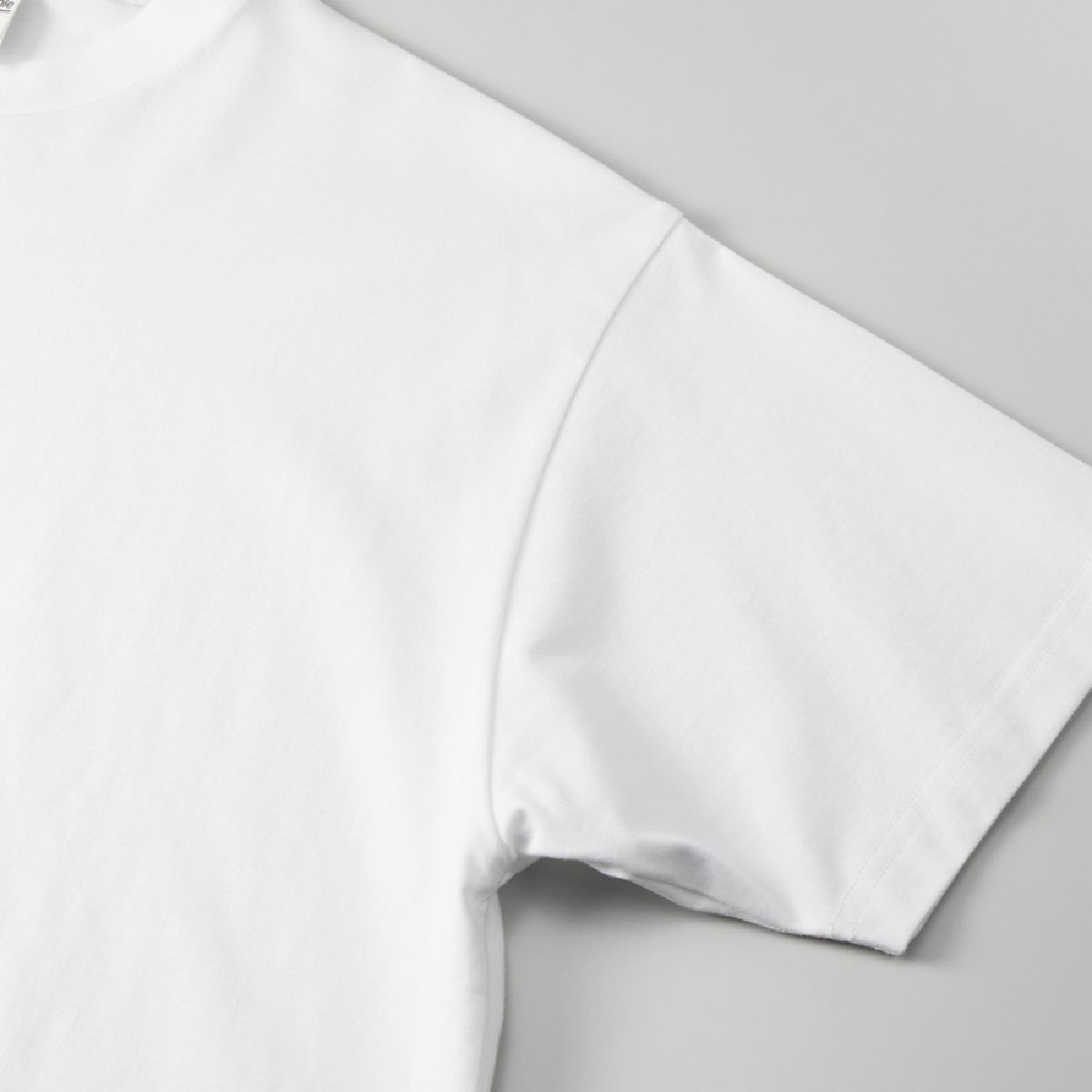 The armholes are finished with overlock stitching, and the cuffs are finished with double-needle stitching.