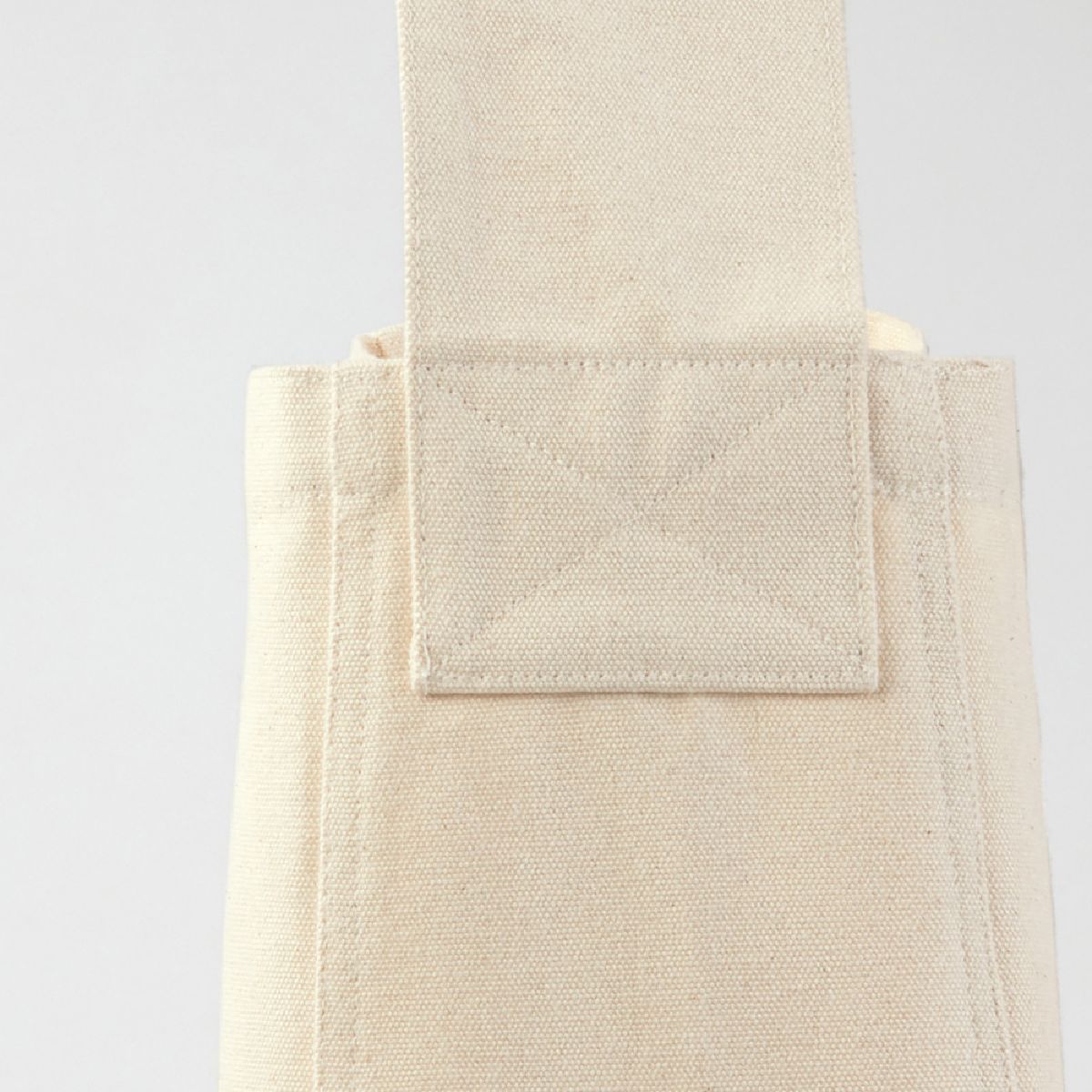 The connection between the main body and the shoulder strap is reinforced with robust stitching.