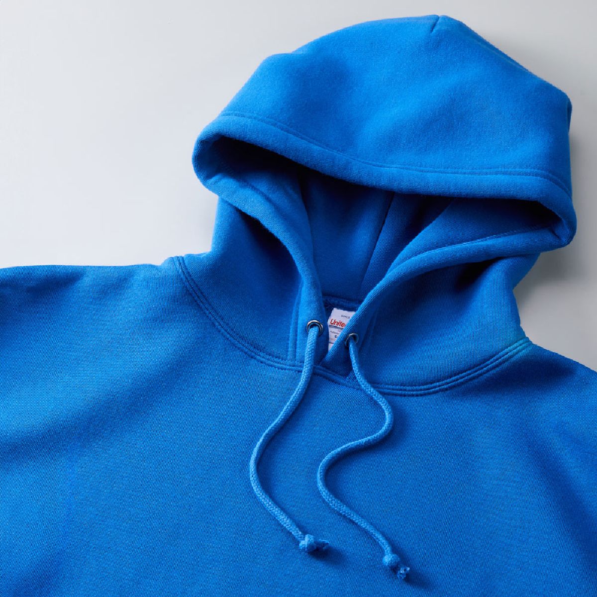 The hood is double-layered and has no front seams, allowing for printing on the hood as well. The hood drawstring is a round cord in the same color as the body.