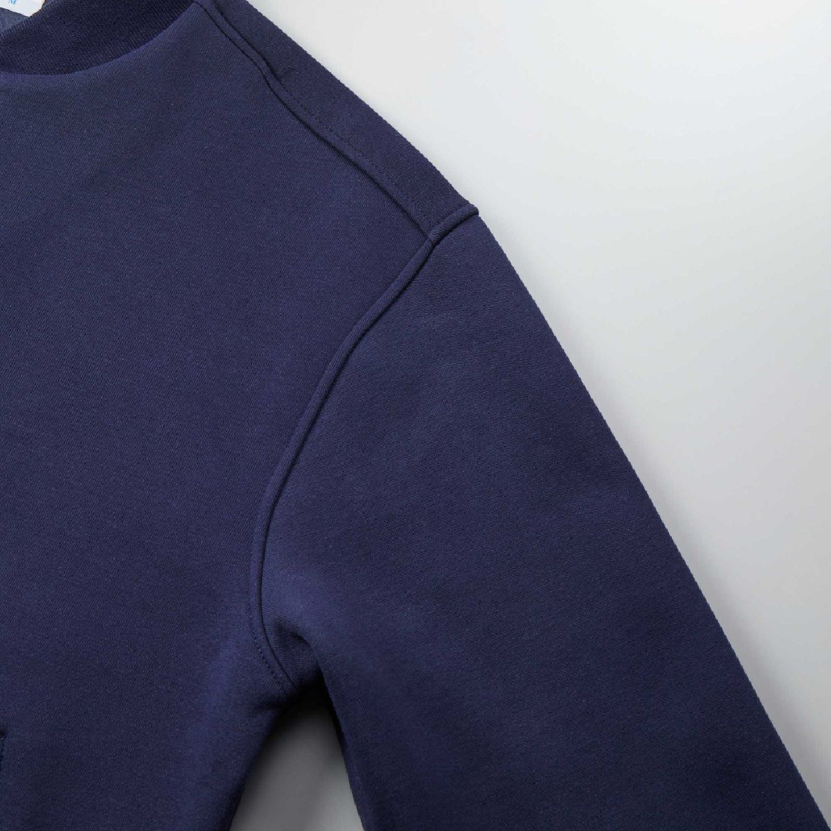 The shoulder line and armholes are reinforced with edge stitching for a robust finish.