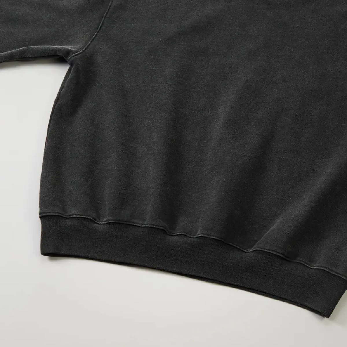 The ribbed cuffs and body seams are finished with a robust double-needle stitching, and the resulting wear marks along the seams create a vintage feel.