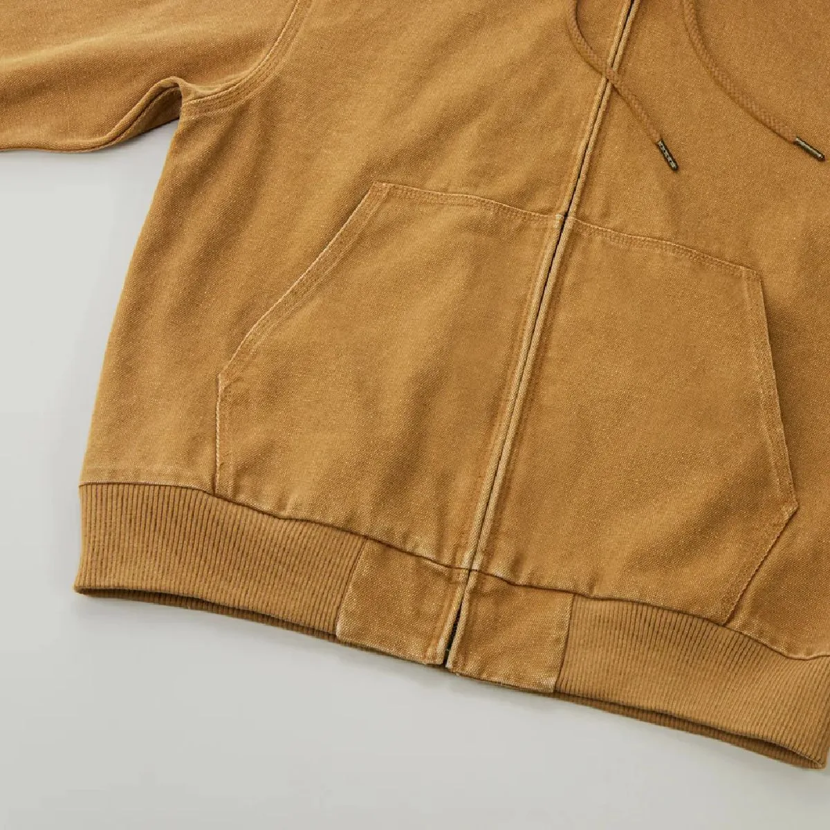 Features a kangaroo pocket, ribbed cuffs, and distressed seams that create a vintage feel.