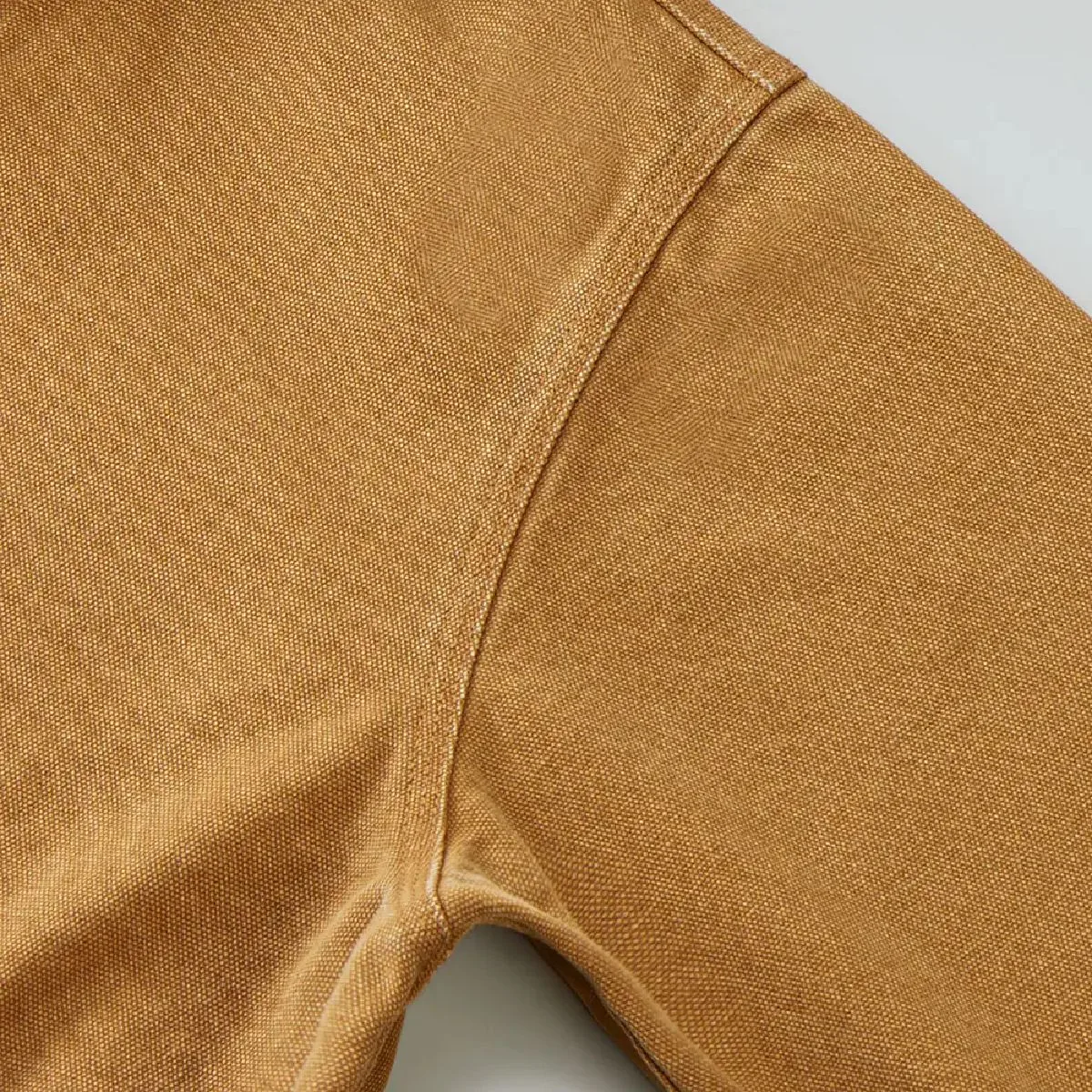 The armholes are finished with durable triple-needle chain stitching, and the resulting wear along the seam lines creates a vintage feel.