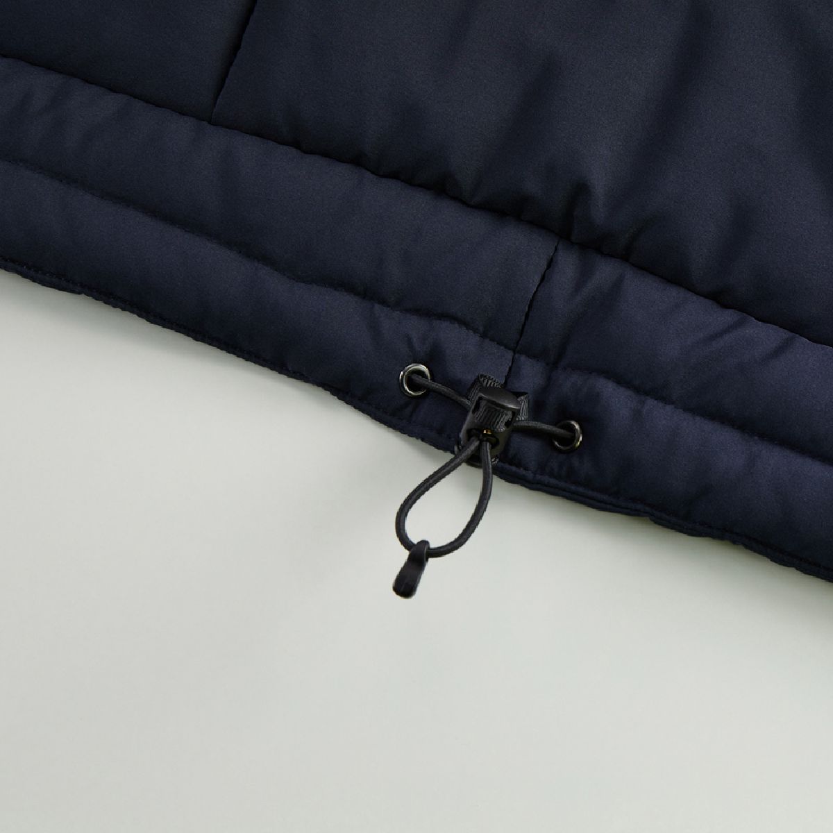 The hem has a drawstring to adjust for wind intrusion and prevent the garment from flapping.
