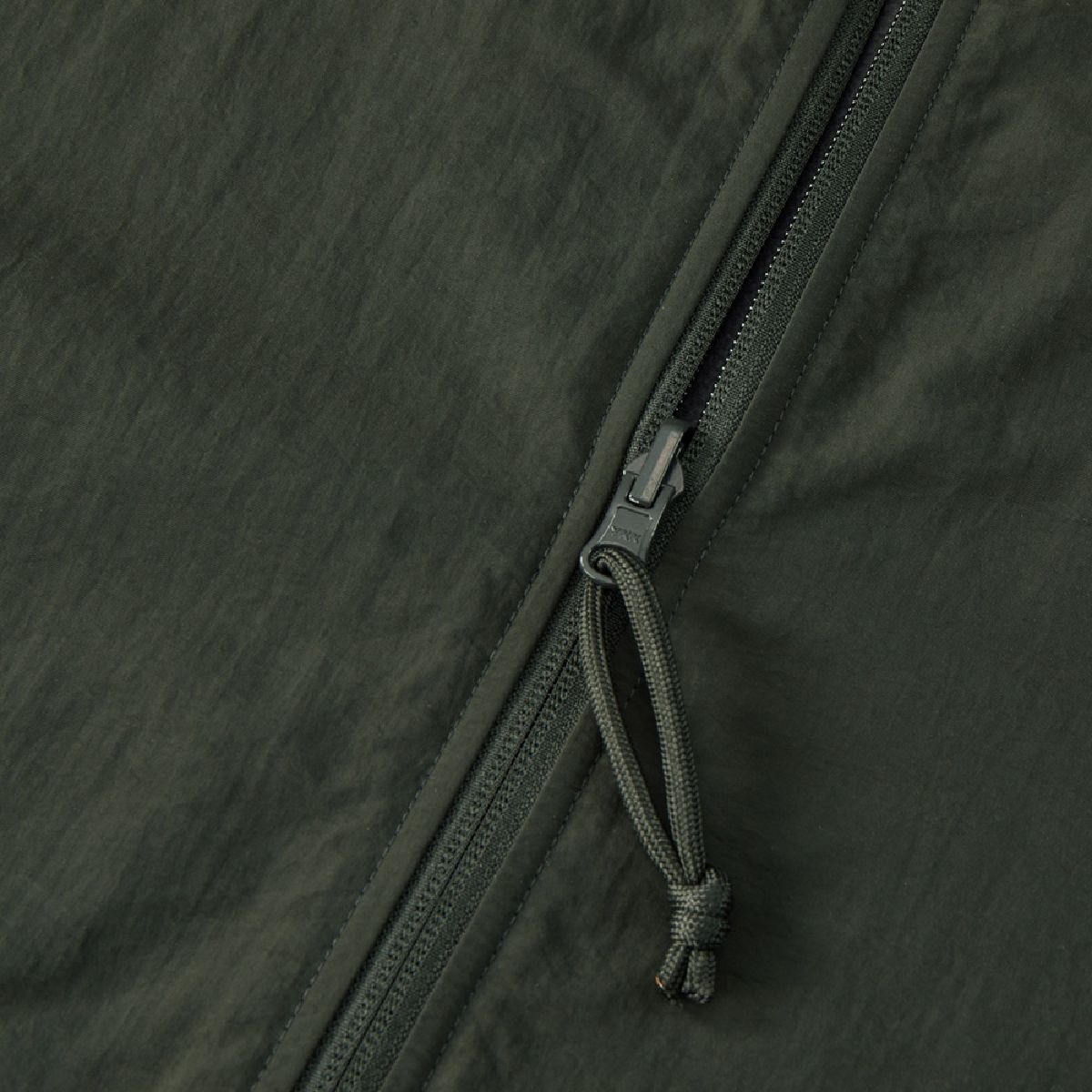 The zipper is a YKK automatic rotating slider, and the paracord pull tab is the same color as the nylon side and the garment body.