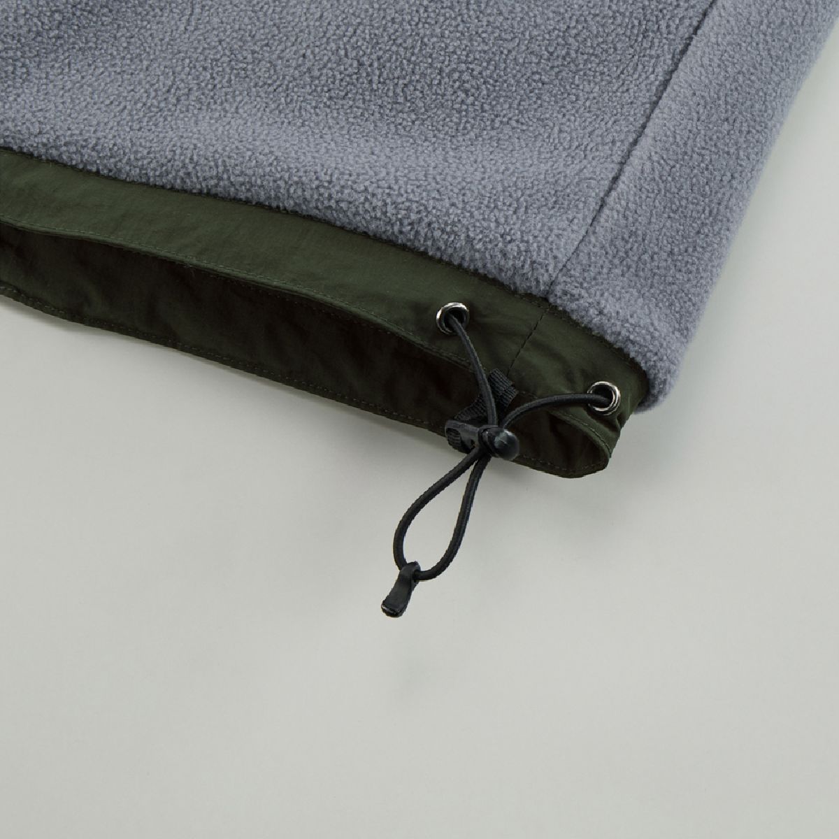 The hem has a drawstring to adjust for wind intrusion and prevent the garment from flapping.